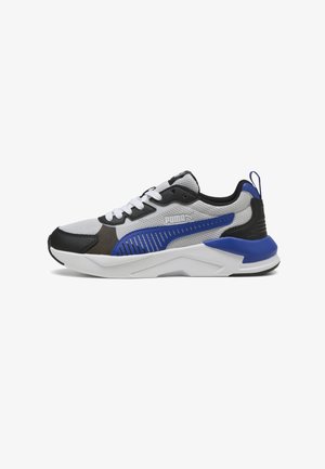 Zapatillas deportivas grises y negras con acentos azules, que cuentan con una parte superior de malla, superposiciones texturizadas, un collar acolchado y una suela blanca gruesa.