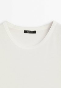 Witte katoenen t-shirt met een ronde halslijn en geribbelde afwerking. Het label leest "Massimo Dutti" met "Made in Marokko" eronder.
