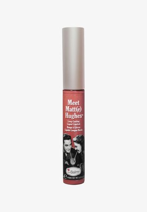 Langanhaltender flüssiger Lippenstift in einer zylindrischen Tube, in einem gedämpften Rosaton. Das Etikett zeigt ein schwarz-weißes Retro-Paar und das Markenlogo.