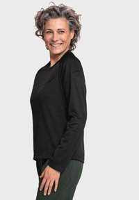 Schwarzes Langarmshirt mit Rundhalsausschnitt; glatte Textur; verfügt über Raglanärmel und ein dezentes Logo auf der Schulter.