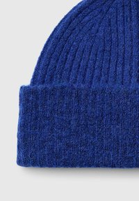 Berretto di lana blu lavorato a maglia con una texture a coste, caratterizzato da un orlo piegato. Il materiale appare morbido e caldo, con un colore uniforme in tutto il berretto.