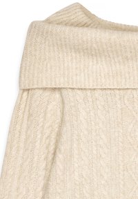 Pull en maille torsadée couleur crème avec col roulé épais à revers côtelé, tissu doux et texturé.