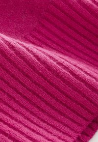 Strukturierter, gerippter Stoff in leuchtendem Pink mit einem weichen, flauschigen Aussehen. Nahaufnahme zeigt abwechselnde dicke und dünne Strickmuster.