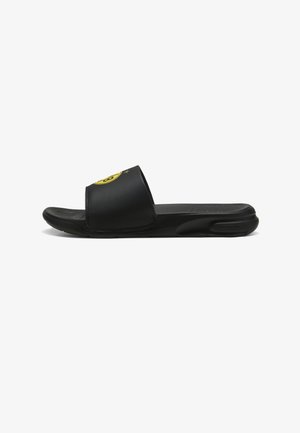 Sort slidesandal med en tekstureret fodseng og glat overdel. Har et gult rundt logo på stroppen. Fleksibel sål for komfort.