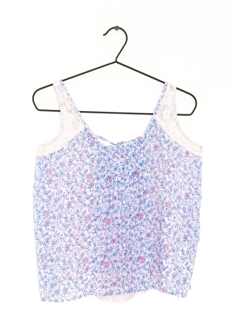 Bloementop met blauwe en roze patronen, gemaakt van lichte stof, met kantaccenten op de schouders en een geplooid ontwerp aan de voorkant.