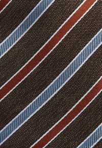 Brun slips med diagonala ränder i blått och orange, med texturerad tyg och kontrasterande tunn vit kant längs ränderna.