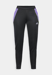Černé sportovní kalhoty s fialovými a zelenými bočními detaily, zúžený střih, elastický pas a logo na stehně. Vyrobeno z elastického materiálu.