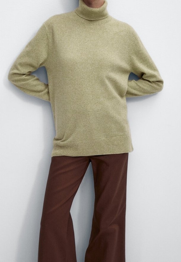 Hellgrüner Rollkragenpullover aus weichem Stoff mit lockerem Schnitt, kombiniert mit braunen Hosen mit weitem Bein. Glatte Textur, minimalistische Details.