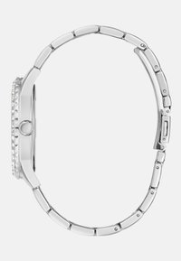 Srebrny zegarek z okrągłą tarczą, ozdobnym pierścieniem i bransoletą z ogniw. Posiada gładkie metalowe ogniwa i zapięcie na zatrzask.