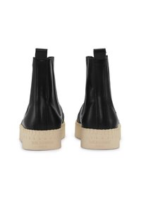 Czarne skórzane botki za kostkę z tanim gumowym podeszewką, z uchwytami i teksturowanym brzegiem. Czysty, minimalistyczny design bez widocznych logo.