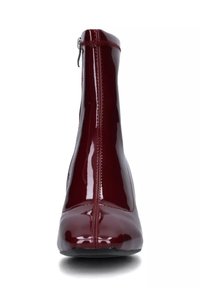 Stivaletto alla caviglia in pelle verniciata bordeaux con silhouette sottile, dettaglio di cuciture rialzate e cerniera laterale per un facile indossamento. Finitura liscia e lucida.