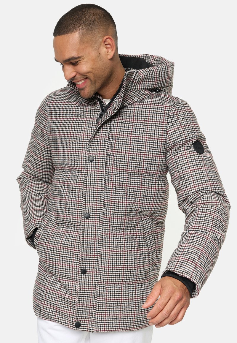 Giacca imbottita a quadri in grigio, rosso e nero, con cappuccio, chiusura con zip, tasche laterali e polsini neri.