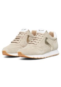 Beige Wildleder-Sneaker mit weißen und goldenen Akzenten, ausgestattet mit einer Schnürung und strukturierten Außensohle. Robuste und vielseitige Schuhe für die Freizeit.