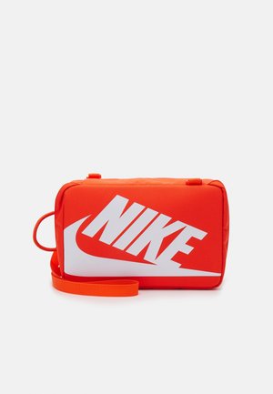 Sac rectangulaire Nike orange vif avec logo blanc en gras, bandoulière réglable et poignée latérale, sur fond uni.