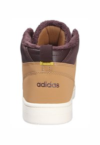 Brązowe wysokie trampki z teksturowaną cholewką, luksusowym kołnierzem, białą gumową podeszwą i wyraźnym logotypem Adidas w kolorze fioletowym na pięcie.