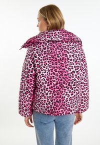 Doplněná bunda s růžovým leopardím potiskem na lesklém materiálu. Vysoký límec a volný střih s elastickými manžetami a lemem.