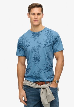 Blue cotton t-shirt featuring a tiger and bamboo pattern in a darker shade. Round neckline, short sleeves, and a relaxed fit.