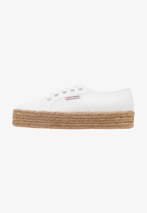 White canvas sneaker with a thick braided jute platform sole. Features six lace eyelets and a small logo tag on the side.