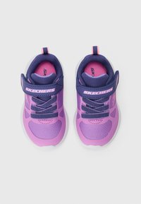Een paar paarse en roze Skechers kindersneakers met klittenbandsluitingen en elastische veters, vanuit bovenaf bekeken op een witte achtergrond.
