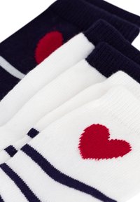 Set di tre calzini nei colori blu navy e bianco, con strisce orizzontali e motivi a cuore rossi. Materiale a maglia morbida, design variabile.