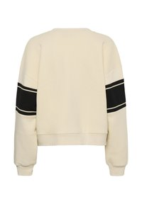 Sweat-shirt de couleur crème avec un design cropped. Présente des rayures noires sur les manches avec des bordures blanches, ainsi que des poignets et un ourlet côtelés.
