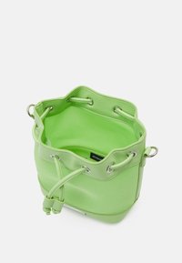 Borsa a secchiello verde chiaro con chiusura a coulisse, occhielli argentati e fondo strutturato, mostrata aperta con un'etichetta interna visibile.