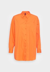 Camicia a maniche lunghe di un brillante arancione con colletto e taschino sul petto, esposta su uno sfondo chiaro e semplice.