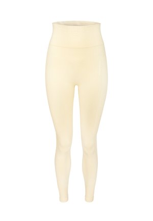 Helle cremefarbene Rippleggings mit hohem Taillenbund. Glatte Textur, figurbetontes Design, mit subtilen Seitennähten und diskretem Branding.