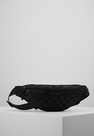 Czarna nerka Fila z subtelnym wzorem logo, regulowanym paskiem z klamrą oraz górną kieszenią na zamek na białym bloku wystawowym.