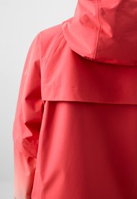 Red waterproof jacket featuring a fitted hood, smooth texture, and a high collar design. Back has a layered flap in the same color.