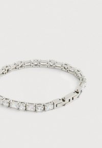 Βραχιόλι σε ασημί τόνο με εναλλασσόμενες ορθογώνιες και στρογγυλές συνθετικές πέτρες, που διαθέτει ομαλή μεταλλική επιφάνεια και ασφαλές κλείσιμο.