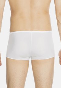 Boxer aderenti bianchi realizzati in un materiale liscio e elastico. Presentano una morbida vita elasticizzata e cuciture precise lungo i bordi.