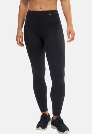 Mallas negras con una cinturilla alta, fabricadas con un tejido suave y elástico. Con un mínimo de marcas y un diseño elegante y ajustado.