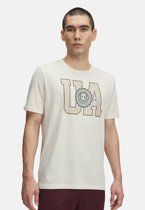Lyscremet bomulds-t-shirt med et stort "UA" grafisk design i brune omridsbogstaver og et cirkulært emblem, korte ærmer og rund hals.