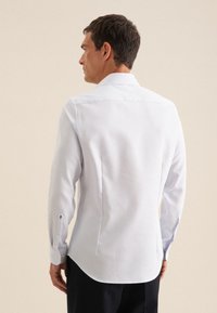 Witte lange mouwen shirt met een subtiel patroon, knoopmanchetten, slim fit en een rugventilatie detail. Glad materiaal met een gestructureerde kraag.