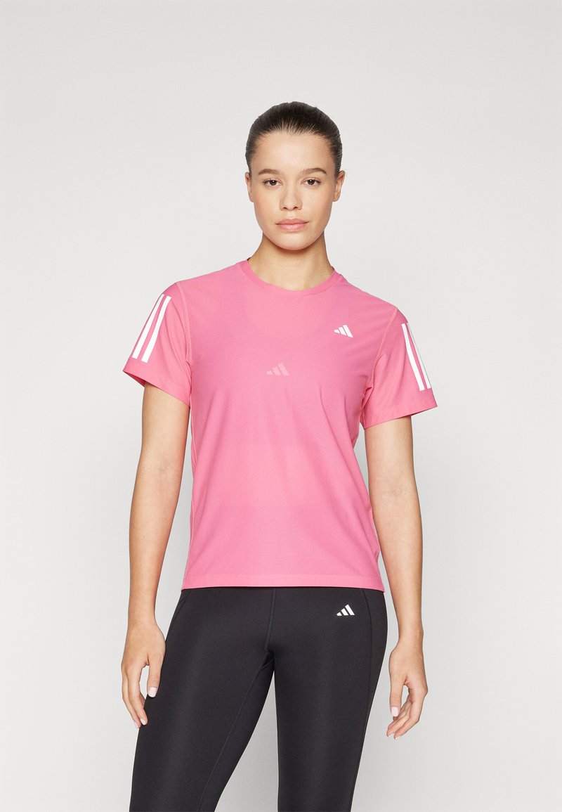 T-shirt sportivo rosa a maniche corte, con eleganti dettagli a strisce bianche sulle spalle e logo del marchio. Tessuto leggero e traspirante.