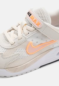 Nike Air Max tenisice s bež mrežastim gornjim dijelom i ružičastim akcentima. Ima bijelu podlogu i istaknuti swoosh logo u narančastoj boji.