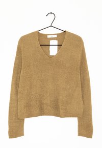 Brązowy sweter z dekoltem w serek, z długim rękawem, wykonany z fakturowanej dzianiny, z krojem w stylu cropped i widoczną metką przy dekolcie.