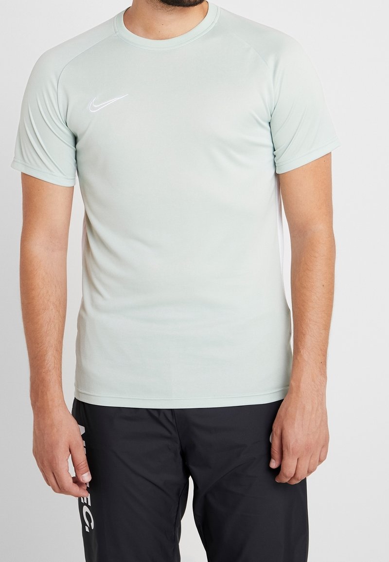 Light green Nike athletic t-shirt with short raglan sleeves. Features a subtle logo on the chest, made from moisture-wicking material.