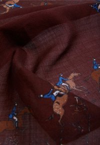 Tela de seda en un rico burdeos con un detallado estampado ecuestre, que representa jinetes sobre caballos. La trama texturada añade una sutil profundidad.