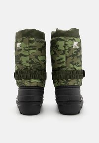 Botas de invierno en camuflaje verde con parte superior acolchada, banda elasticada y suela de goma. Presenta un logotipo y detalles texturizados en el caña.