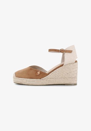 Wedge de esparto en ante color marrón claro con una suela intermedia de yute tejido, correa en el tobillo y un reverso texturizado en crema, que presenta un pequeño acento de logo metálico.