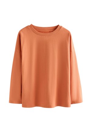 Långärmad orange bomullsskjorta med rund halsringning, avslappnad passform och sänkt axel. Slät textur och minimala sömnadsdetaljer.