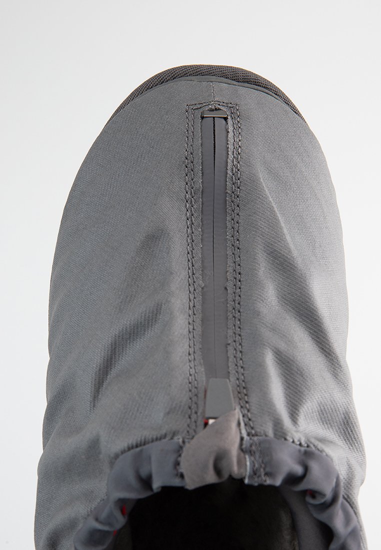 Cubierta de zapato gris con una cremallera impermeable central y una abertura elástica para un ajuste seguro sobre el calzado.