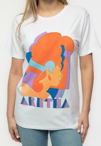 White cotton t-shirt featuring a colorful graphic design of a profile with abstract shapes in orange, blue, and purple. Text reads "ARETHA."