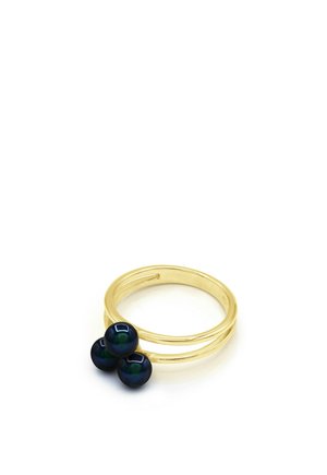 Bague double bande en or ornée de trois perles iridescentes foncées regroupées sur un fond blanc.