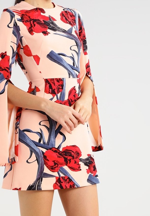 Blomsterkjole med røde og blå blomsterprints på en ferskenfarvet baggrund, med lange ærmer og en tætsiddende silhuet.