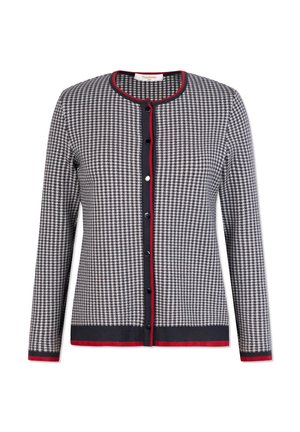 Sveter s gombíkmi v čierno-bielom vzore houndstooth. Má námornícky lem s červenými detailmi, dlhé rukávy a okrúhly výstrih.