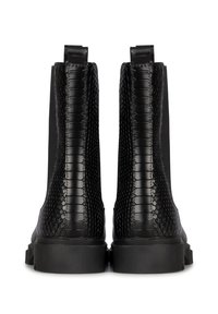 Botas de tobillo de cuero negro con un patrón de reptil texturizado y parte superior suave. Presentan una suela plana y lengüetas en la parte trasera para ponérselas fácilmente.