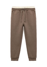 Braune, strukturierte Jogginghosen mit elastischem Bund und Kordelzug, versehen mit Cremetönen. Die Bündchen sind eng an den Knöcheln.